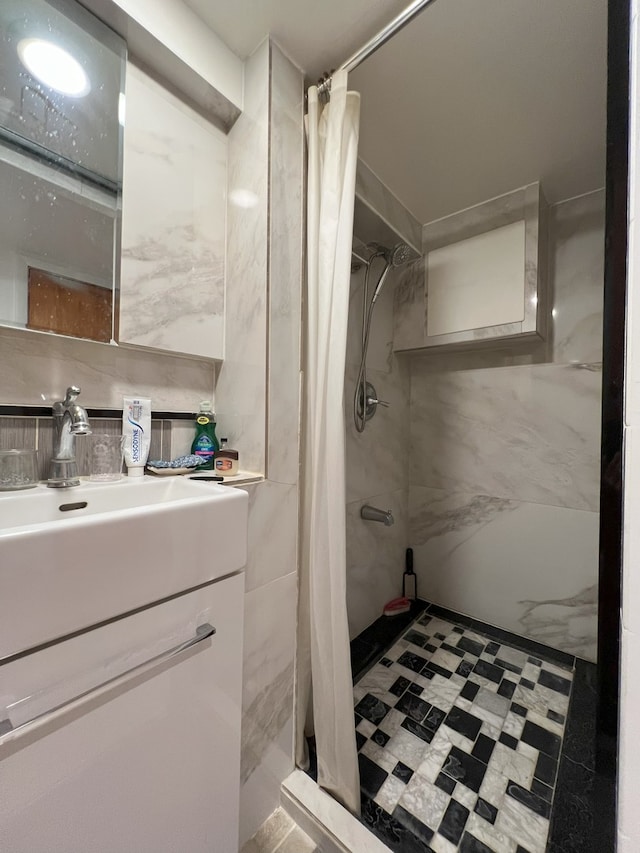 bathroom with tile walls, vanity, and curtained shower