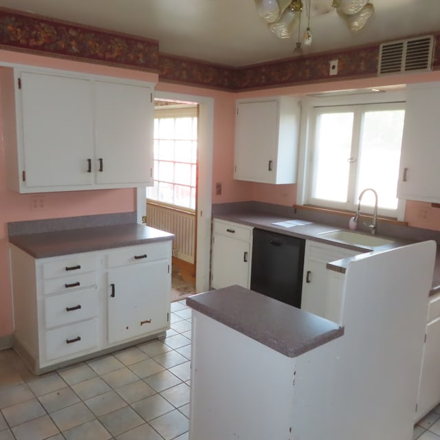 kitchen featuring dishwasher, sink, light tile patterned floors, and white cabinets