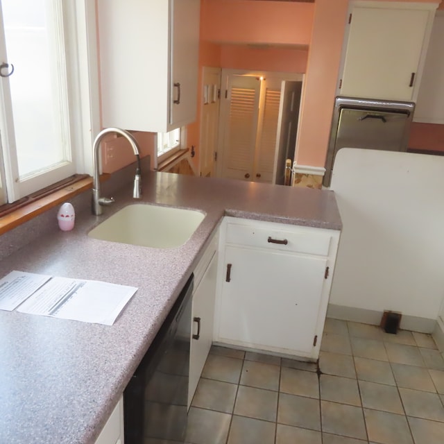 kitchen featuring a healthy amount of sunlight, white cabinetry, sink, and light tile patterned floors