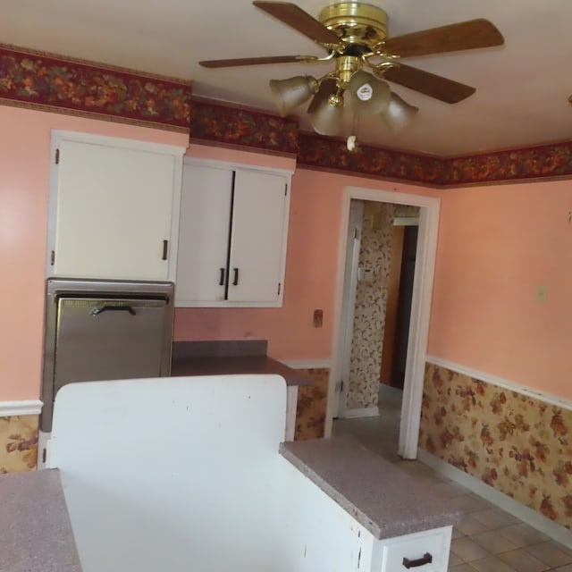 kitchen with light tile patterned floors, ceiling fan, and white cabinets