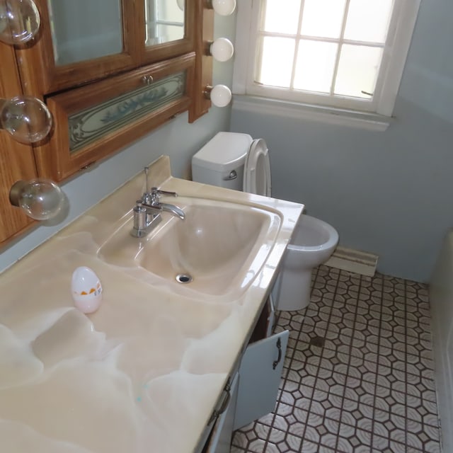 bathroom with tile patterned flooring, vanity, and toilet