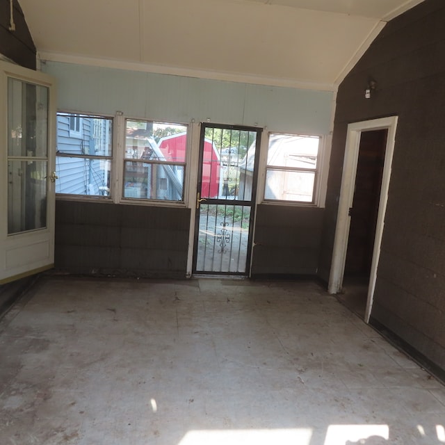 unfurnished room with lofted ceiling