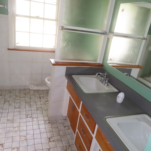 bathroom featuring vanity, tile walls, toilet, and tile patterned floors