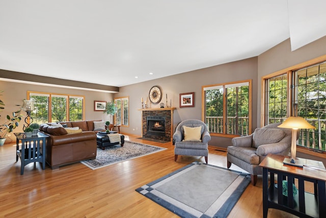 living room with light wood-type flooring and a stone fireplace