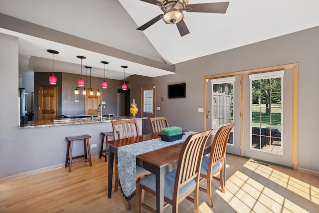 dining room with light hardwood / wood-style floors, vaulted ceiling, and ceiling fan