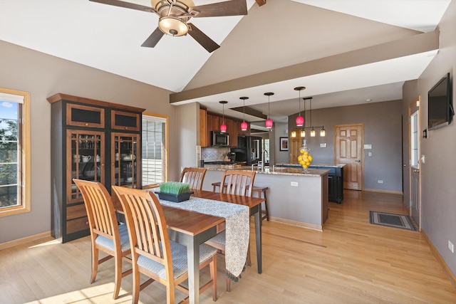 dining space with light wood-type flooring, vaulted ceiling, ceiling fan, and sink