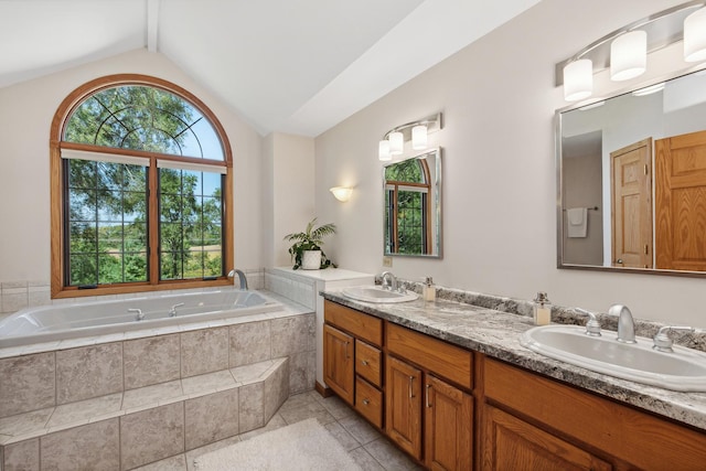 bathroom with vanity, tile patterned floors, lofted ceiling, and tiled tub