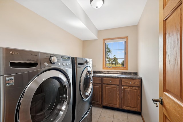 laundry room with cabinets, light tile patterned floors, and washer and clothes dryer