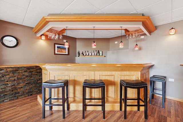 bar with pendant lighting and hardwood / wood-style flooring