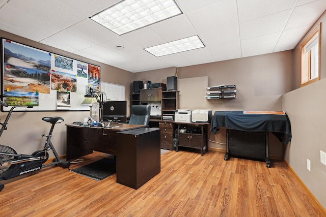 office area with light hardwood / wood-style floors and a drop ceiling