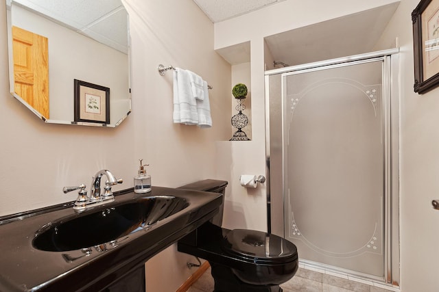 bathroom with toilet, an enclosed shower, and sink