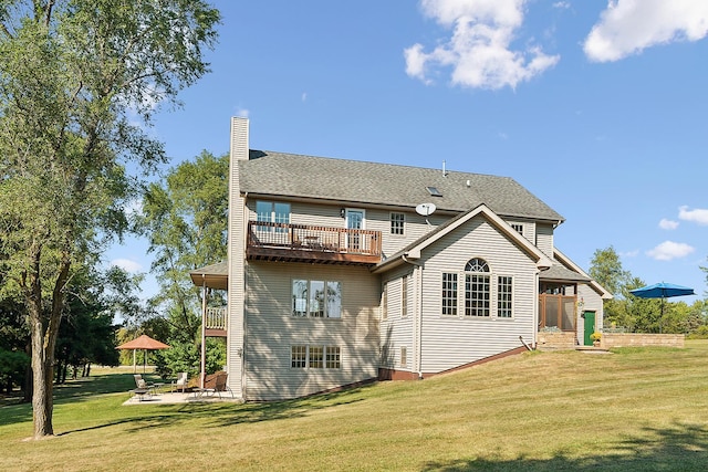 rear view of property with a yard and a balcony