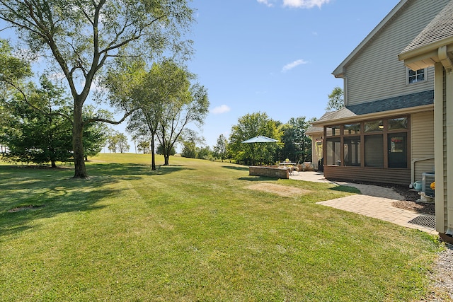 view of yard with a sunroom and a patio