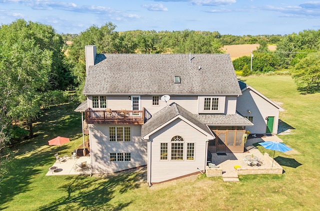 back of house with a lawn, a deck, and a patio