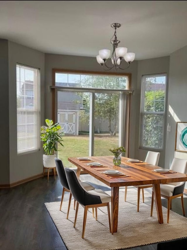 dining room with a healthy amount of sunlight, baseboards, dark wood-style floors, and a notable chandelier