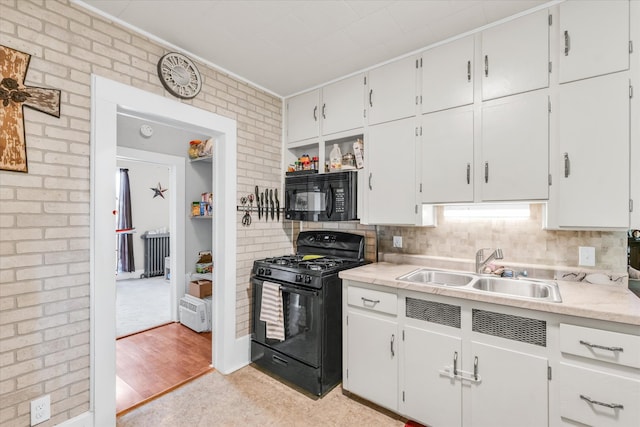 kitchen featuring white cabinets, light wood-type flooring, sink, and black appliances