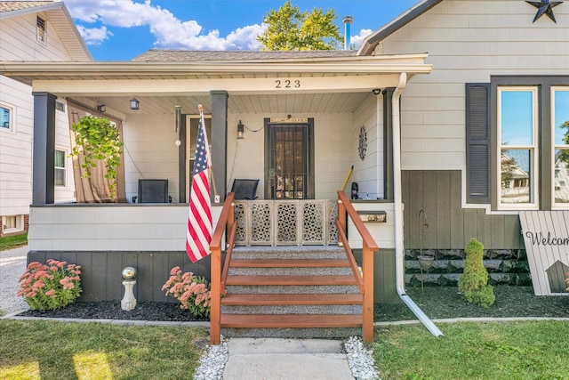 view of exterior entry featuring covered porch