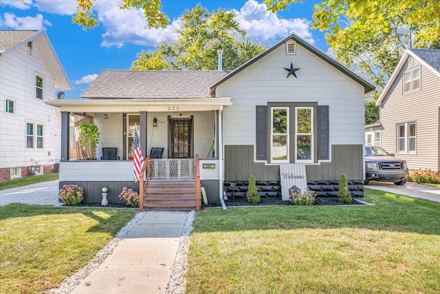 bungalow with a front lawn and covered porch