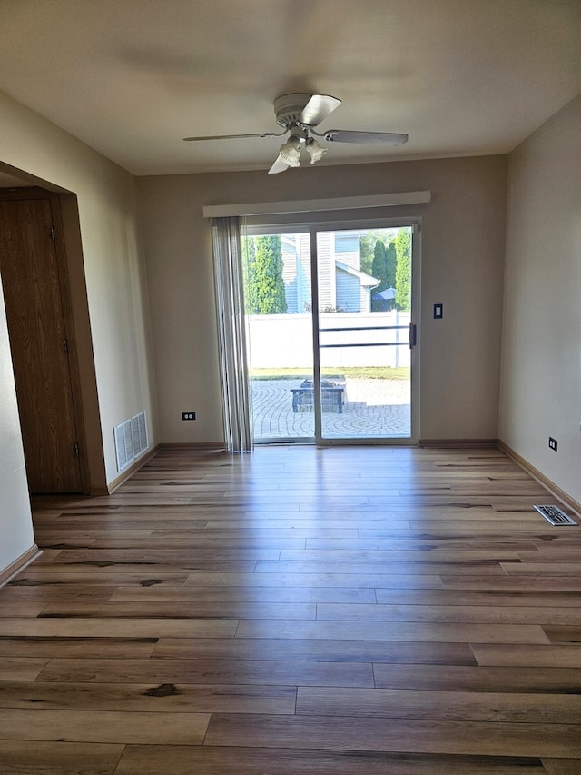 empty room with dark hardwood / wood-style floors and ceiling fan