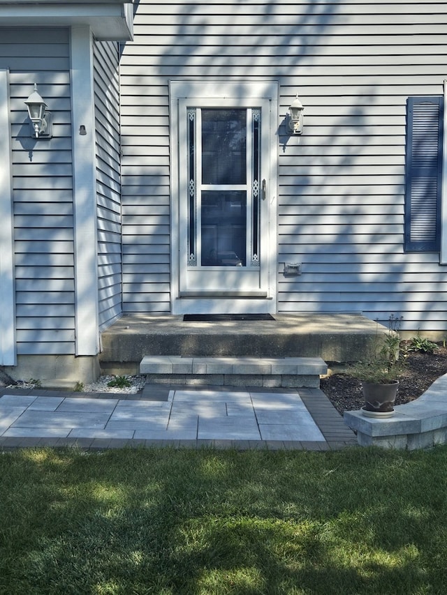 view of exterior entry featuring a yard