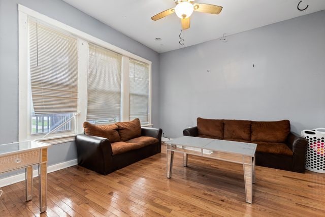 living room featuring light hardwood / wood-style flooring and ceiling fan