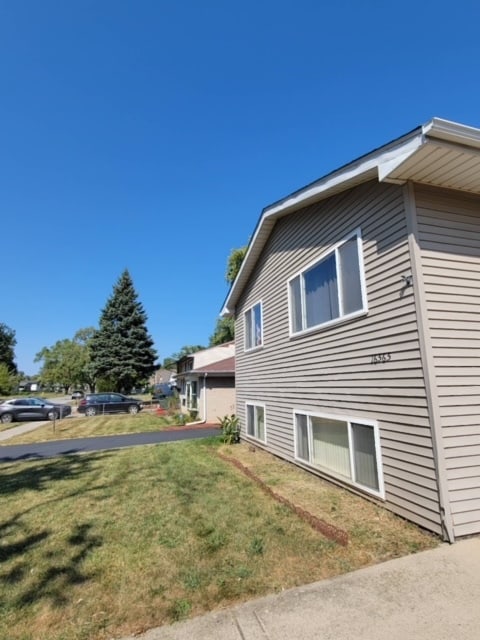 view of side of home featuring a lawn and a garage