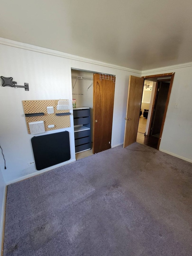 unfurnished bedroom with carpet floors, crown molding, and a closet