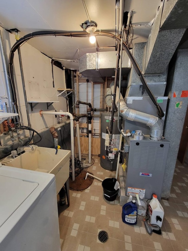 utility room with water heater and washer / dryer