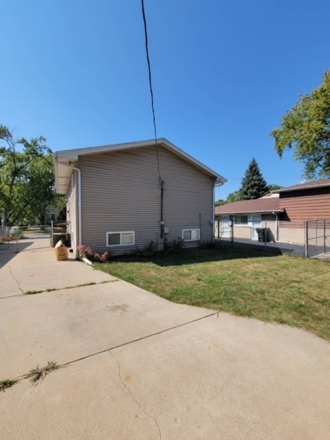 view of side of home featuring a yard and a patio area