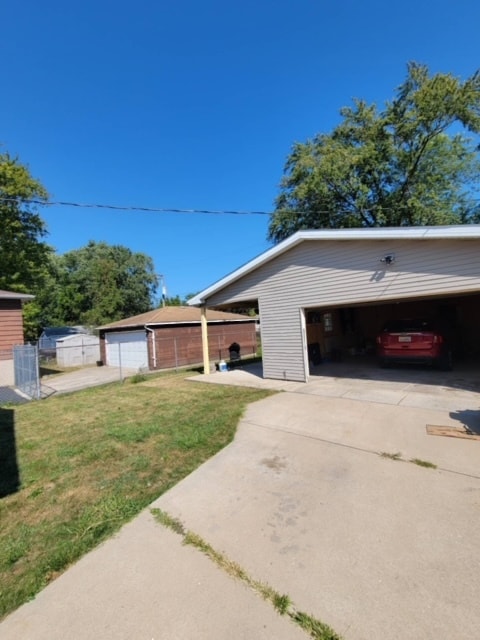 view of home's exterior featuring a garage, an outdoor structure, and a yard