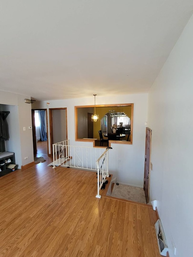 interior space with a notable chandelier, a wealth of natural light, and hardwood / wood-style floors