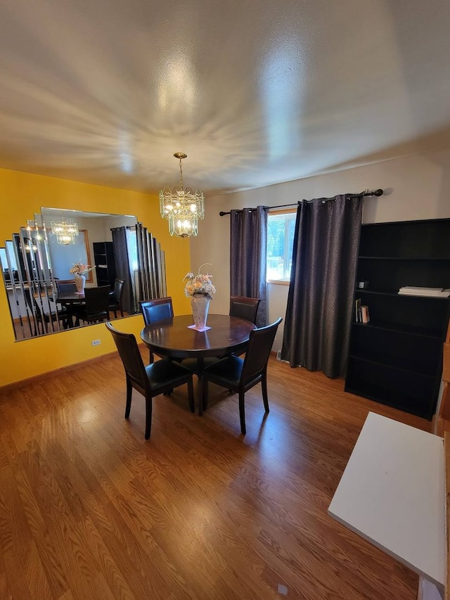 dining space featuring hardwood / wood-style flooring and a notable chandelier