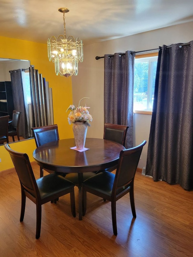 dining room with wood-type flooring and a notable chandelier