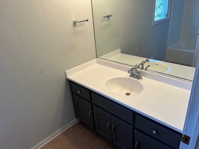 bathroom with tile patterned flooring, a bath, and vanity