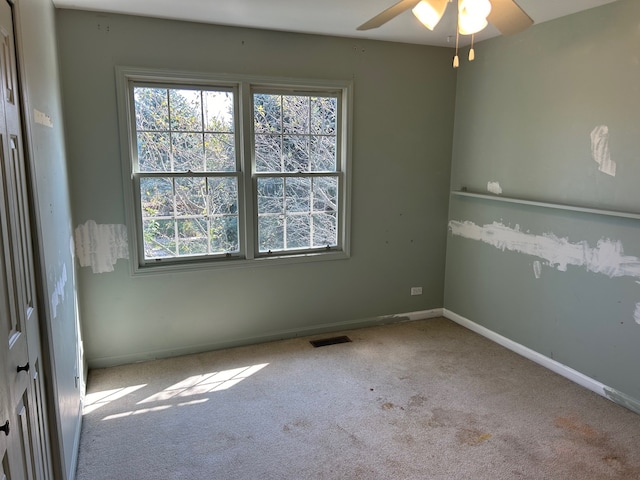 carpeted empty room featuring ceiling fan