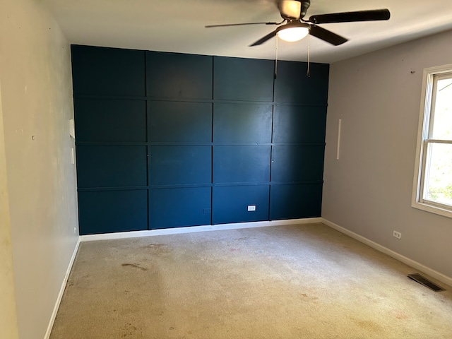 spare room with carpet flooring, ceiling fan, and a wealth of natural light