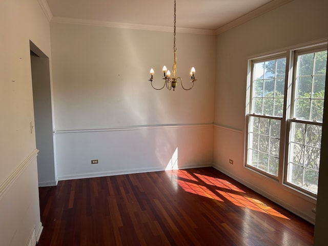 spare room featuring ornamental molding, dark hardwood / wood-style floors, and a chandelier