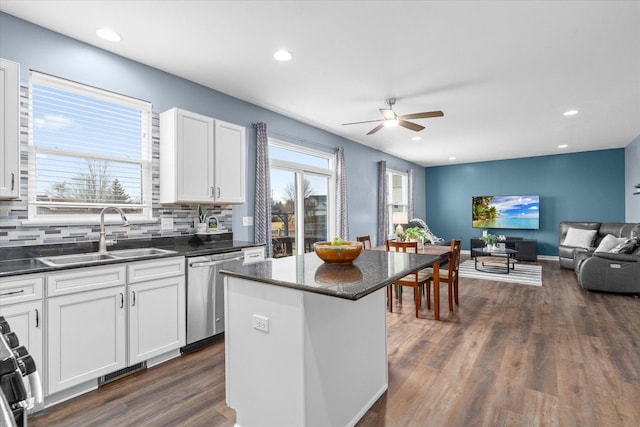 kitchen with white cabinetry, sink, dishwasher, and a kitchen island