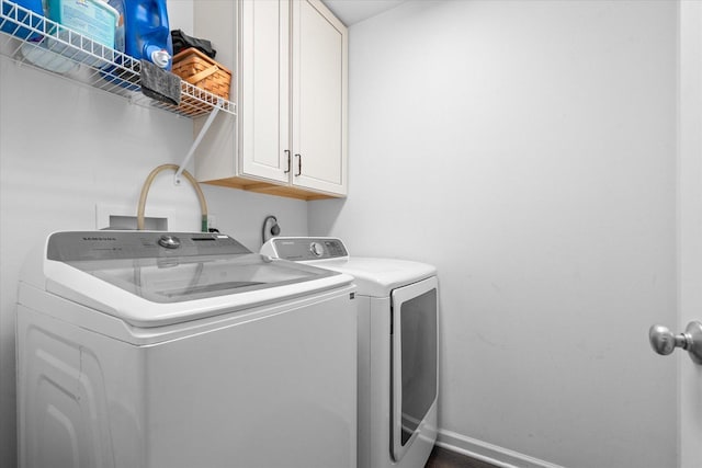 washroom with cabinets and washing machine and clothes dryer