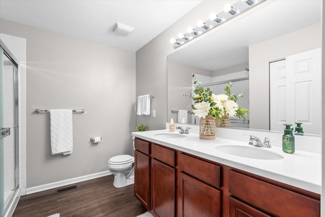 bathroom featuring vanity, hardwood / wood-style floors, an enclosed shower, and toilet