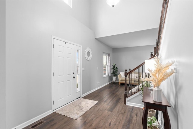 entryway featuring a high ceiling and dark wood-type flooring