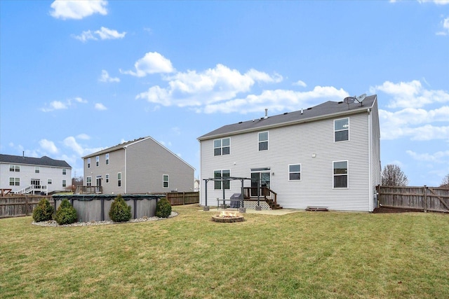 back of house with a lawn and a covered pool