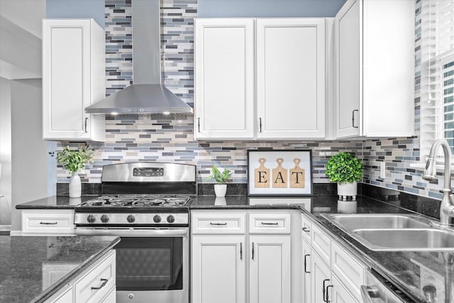 kitchen with wall chimney exhaust hood, sink, white cabinetry, appliances with stainless steel finishes, and backsplash