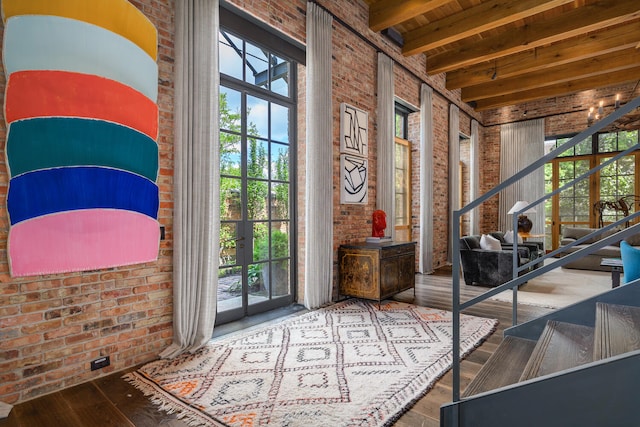 entryway with wood-type flooring, beamed ceiling, and plenty of natural light