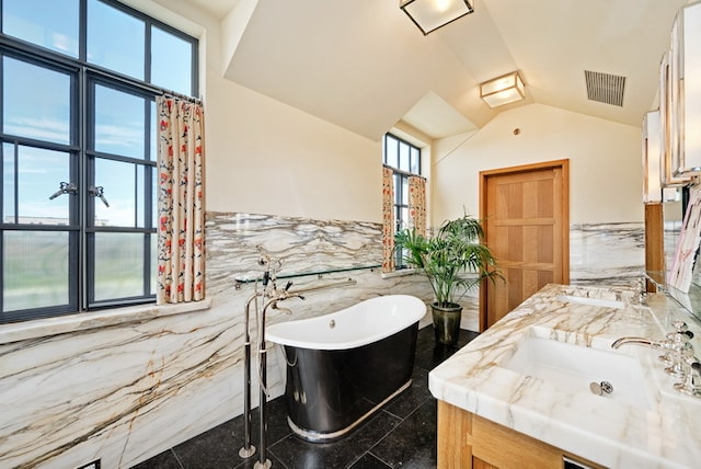 bathroom featuring tile walls, lofted ceiling, vanity, and separate shower and tub