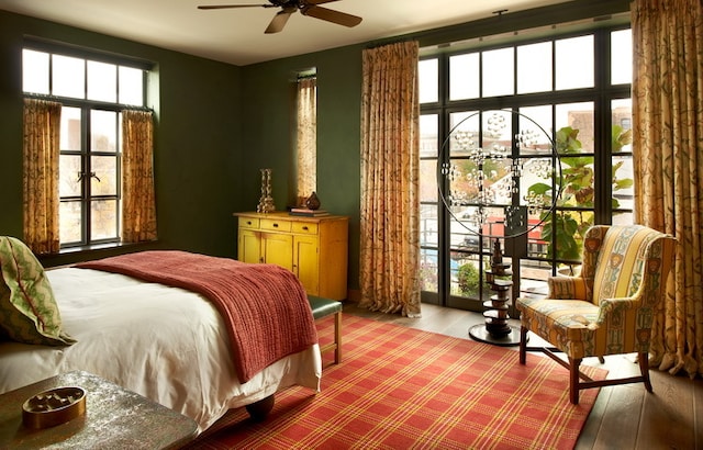 bedroom with wood-type flooring, multiple windows, and ceiling fan