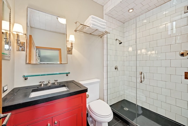 bathroom featuring vanity, toilet, a shower with door, and tile patterned floors