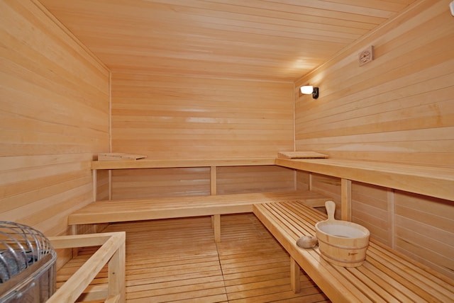 view of sauna with wooden ceiling and wooden walls