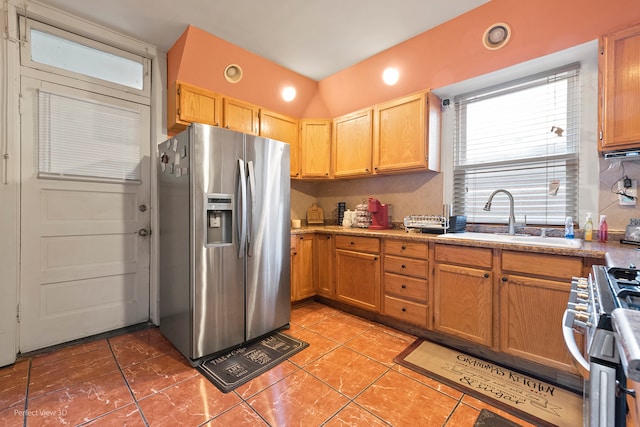 kitchen featuring stainless steel appliances, backsplash, light tile patterned floors, and sink