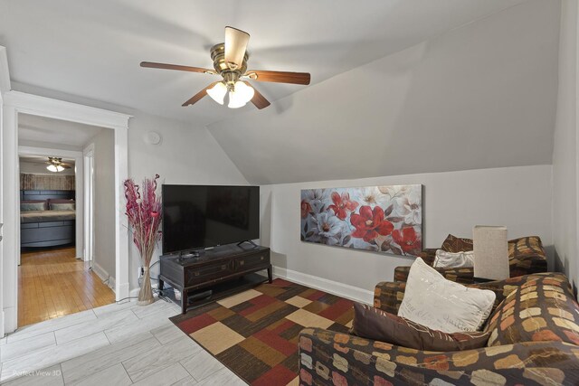 interior space with light wood-type flooring, lofted ceiling, and ceiling fan